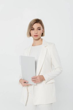 Takım elbiseli sarışın iş kadını, gri klasörde izole edilmiş kâğıt klasörü tutuyor. 
