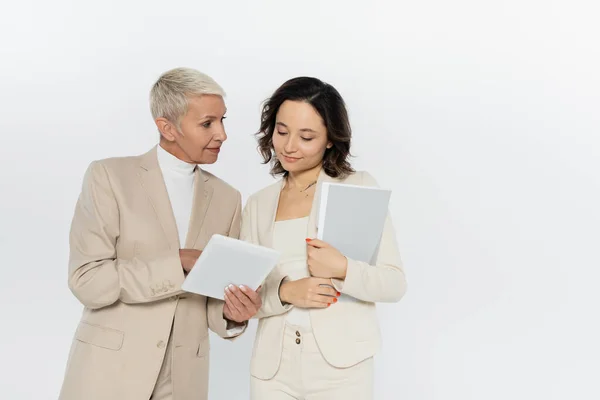 Senior Geschäftsfrau Hält Digitales Tablet Neben Kollegin Mit Papiermappe Isoliert — Stockfoto