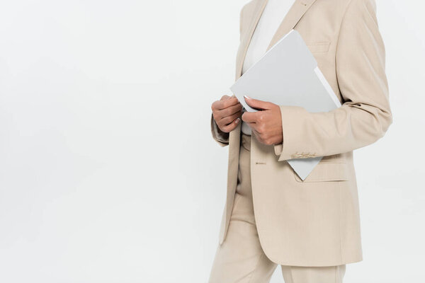 Cropped view of businesswoman in suit holding paper folder isolated on grey 