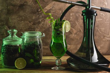 Kokteyl, kuru çay ve nargile ahşap yüzeyde dokulu taş arka planda. 