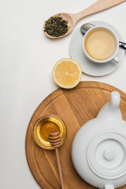 Beyaz arkaplanda bal ve limon yakınındaki çaydanlığın üst görüntüsü 