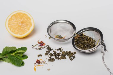 Nanenin yanında kurutulmuş çay ve beyaz arka planda limon. 