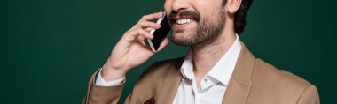 Bıyıklı mutlu bir genç adam koyu yeşil bir telefonla konuşuyor, afiş.