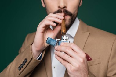 Bıyıklı, elinde puro tutan, koyu yeşil alevli adamın kısmi görüntüsü 