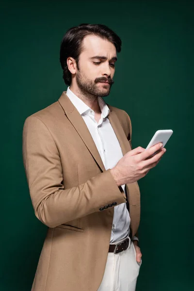 Junger Mann Mit Schnurrbart Benutzt Smartphone Auf Dunkelgrün — Stockfoto