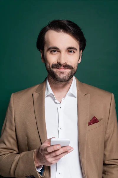 Joven Feliz Con Bigote Sosteniendo Teléfono Inteligente Verde Oscuro —  Fotos de Stock