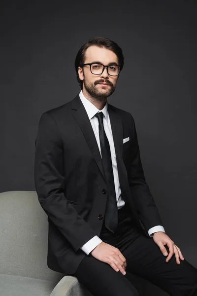 Hombre Negocios Ropa Formal Gafas Apoyadas Sillón Gris Oscuro —  Fotos de Stock