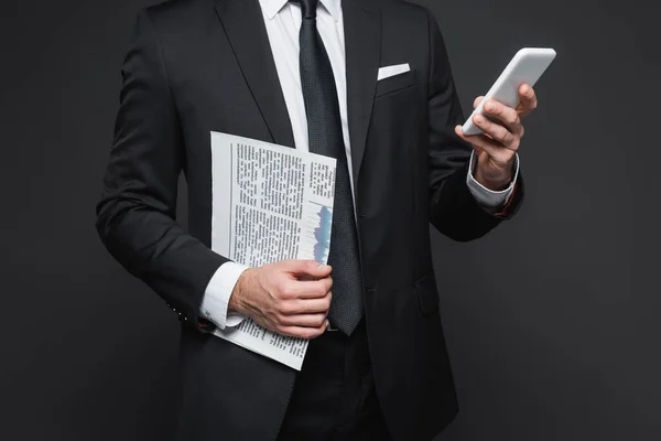 穿着西装的商人拿着报纸 在深灰色背景下使用智能手机的剪影 — 图库照片
