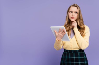 Mor üzerine izole edilmiş dijital tablet kullanan düşünceli genç kadın