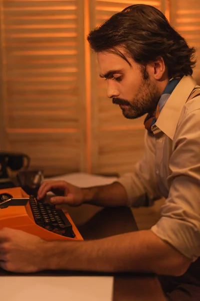 side view of writer using typewriter machine