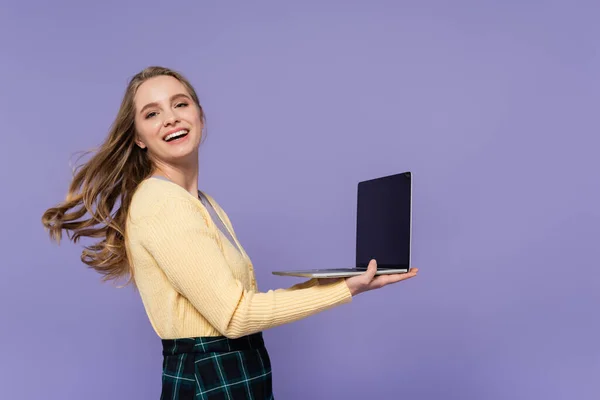 Alegre Joven Mujer Sosteniendo Portátil Con Pantalla Blanco Aislado Púrpura — Foto de Stock