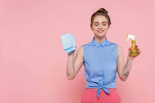 Pleased Tattooed Young Woman Holding Blue Rag Spray Bottle Isolated — Stock Photo, Image