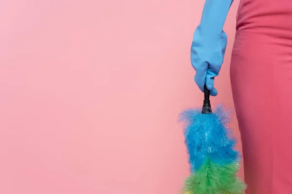 穿着蓝色橡胶手套的女人拿着用粉红隔离的灰尘刷的剪影 — 图库照片