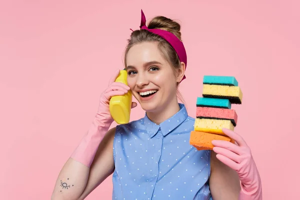 Feliz Joven Con Guantes Goma Sosteniendo Esponjas Apiladas Botella Aislada — Foto de Stock