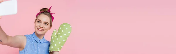 快乐的年轻女子 戴着绿色烘焙手套 拿着自己的东西在智能手机上挂着粉红色的横幅 — 图库照片