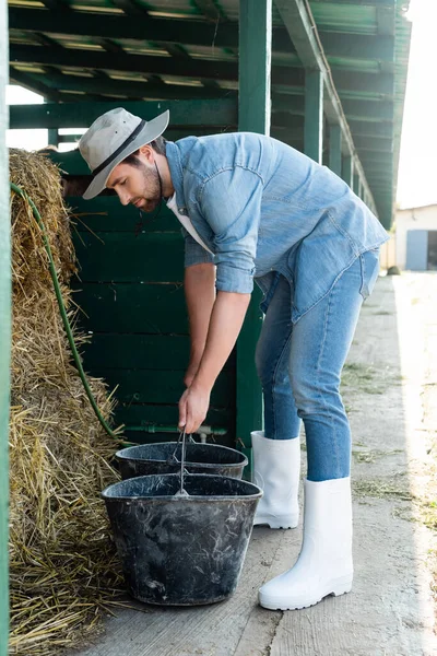 Ganzkörperansicht Eines Bauern Jeanskleidung Und Gummistiefeln Der Eimer Der Nähe — Stockfoto