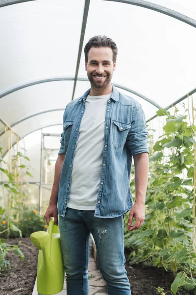 Joven Agricultor Con Regadera Sonriendo Cámara Invernadero — Foto de Stock