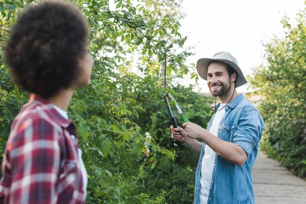 Cheerful Gardener Cutting Bushes Blurred African American Woman — Stock Photo, Image