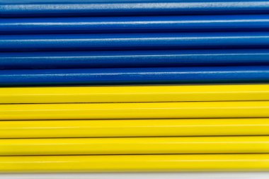 Beyaz üzerine sarı ve mavi renkli kalemlerin üst görünümü 