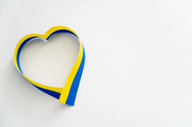 Beyaz arkaplanda mavi ve sarı kurdelelerin üst görünümü