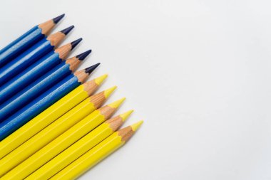 Beyaz arkaplandaki sarı ve mavi renkli kalemlerin üst görünümü