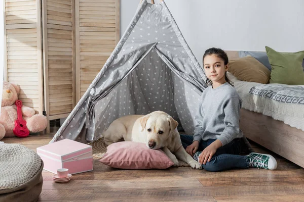 Preteen Menina Olhando Para Câmera Perto Labrador Deitado Travesseiro Wigwam — Fotografia de Stock