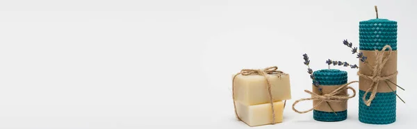 Handmade candles with craft paper and soap on grey background, banner 