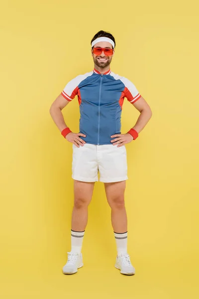 Full Length Smiling Sportsman Sunglasses Holding Hands Hips Yellow Background — Stock Photo, Image