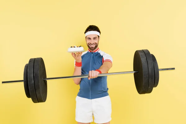 Leende Idrottsman Håller Skivstång Och Tårta Isolerad Gul — Stockfoto