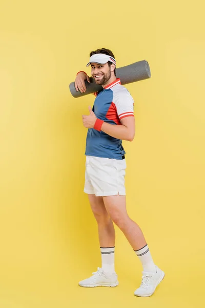 Full Length Smiling Sportsman Showing Holding Fitness Mat Yellow Background — Stock Photo, Image