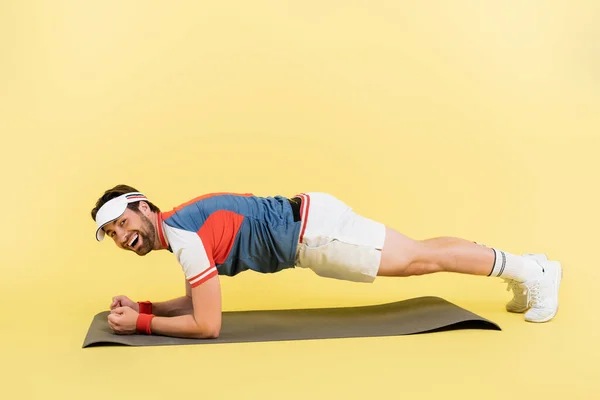 Positive Sportsman Standing Plank Fitness Mat Yellow Background — Stock Photo, Image