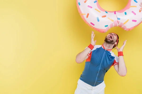 Junger Sportler Öffnet Mund Unter Schwimmring Auf Gelbem Hintergrund — Stockfoto