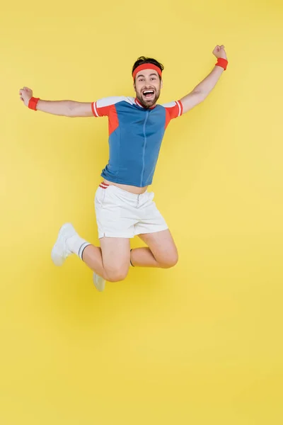 Emocionado Deportista Saltando Mostrando Gesto Aislado Amarillo — Foto de Stock