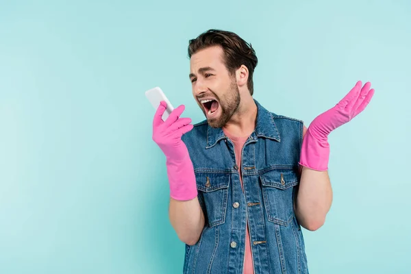 Homem Irritado Luvas Borracha Olhando Para Smartphone Isolado Azul — Fotografia de Stock