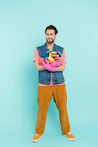 Hombre Sonriente Con Guantes Goma Sosteniendo Esponjas Sobre Fondo Azul —  Fotos de Stock