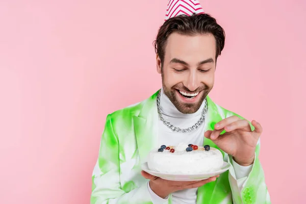 Homem Positivo Tampa Partido Segurando Bolo Aniversário Isolado Rosa — Fotografia de Stock