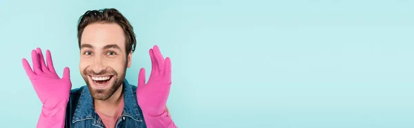 Vrolijke Man Rubberen Handschoenen Kijkend Naar Camera Geïsoleerd Blauw Banner — Stockfoto
