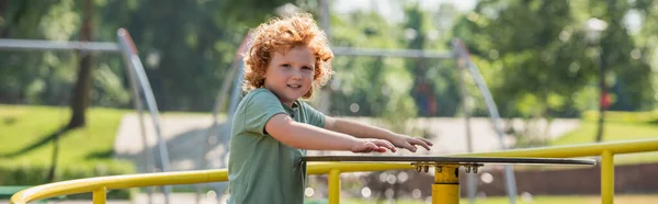 Redhead Kid Looking Camera While Riding Carousel Summer Park Banner — Stock Photo, Image