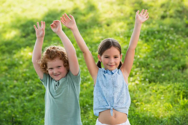 Happy Brother Sister Looking Camera While Standing Raised Hands Outdoors — Stock Photo, Image