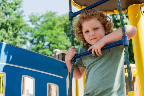 Niño Escalera Cuerda Mirando Cámara Mientras Pasa Tiempo Patio Recreo —  Fotos de Stock