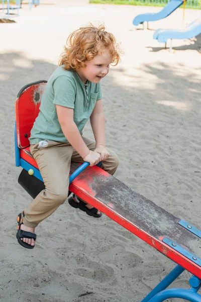 Visão Comprimento Total Menino Ruivo Feliz Cavalgando Baleia Parque Diversões — Fotografia de Stock