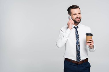 Gri renkte izole edilmiş akıllı telefondan konuşurken gülümseyen bir ekonomist.