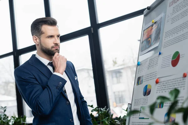 Economista Pensativo Olhando Para Flip Chart Com Gráficos Escritório — Fotografia de Stock