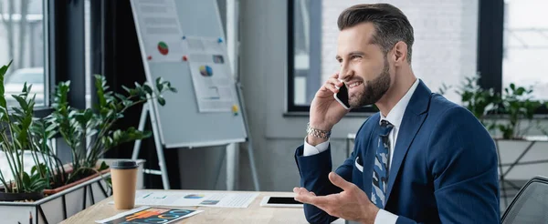 Economista Sonriente Gesticulando Hablando Teléfono Inteligente Cerca Del Café Para — Foto de Stock