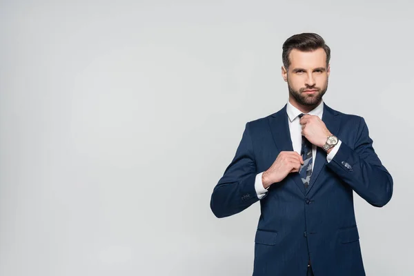 Brunette Businessman Adjusting Tie While Looking Camera Isolated Grey — 스톡 사진