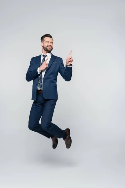 Cheerful Businessman Levitating Pointing Fingers Grey — Stock Photo, Image