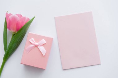 Hediye kutusunun yanındaki zarfın üst görüntüsü ve beyaz üzerinde pembe lale 