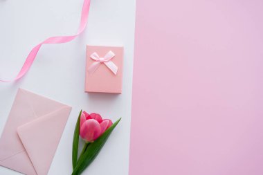 Hediye kutusunun yanındaki zarf manzarası ve beyaz ve pembe lale.