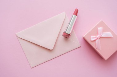 Zarfın yanında ruj izi ve pembe hediye paketi.