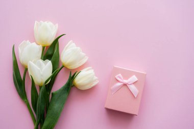Beyaz lalelerin üst görüntüsü Pembe hediye kutusunun yanında